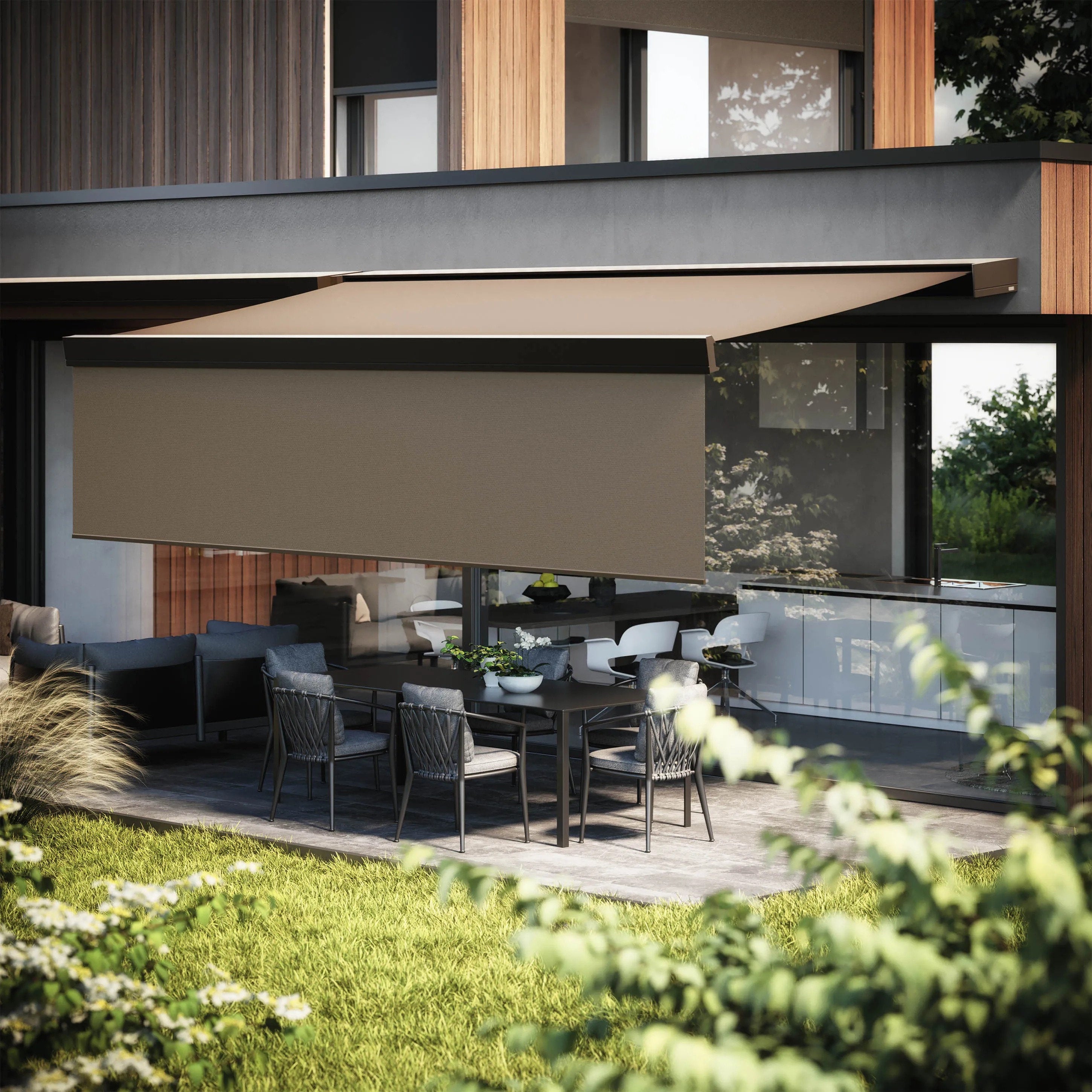 Tenda da sole a bracci estensibili con mantovana frontale abbassata, installata su facciata moderna in legno e cemento, ombreggia un'area pranzo esterna – Domotea Milano.