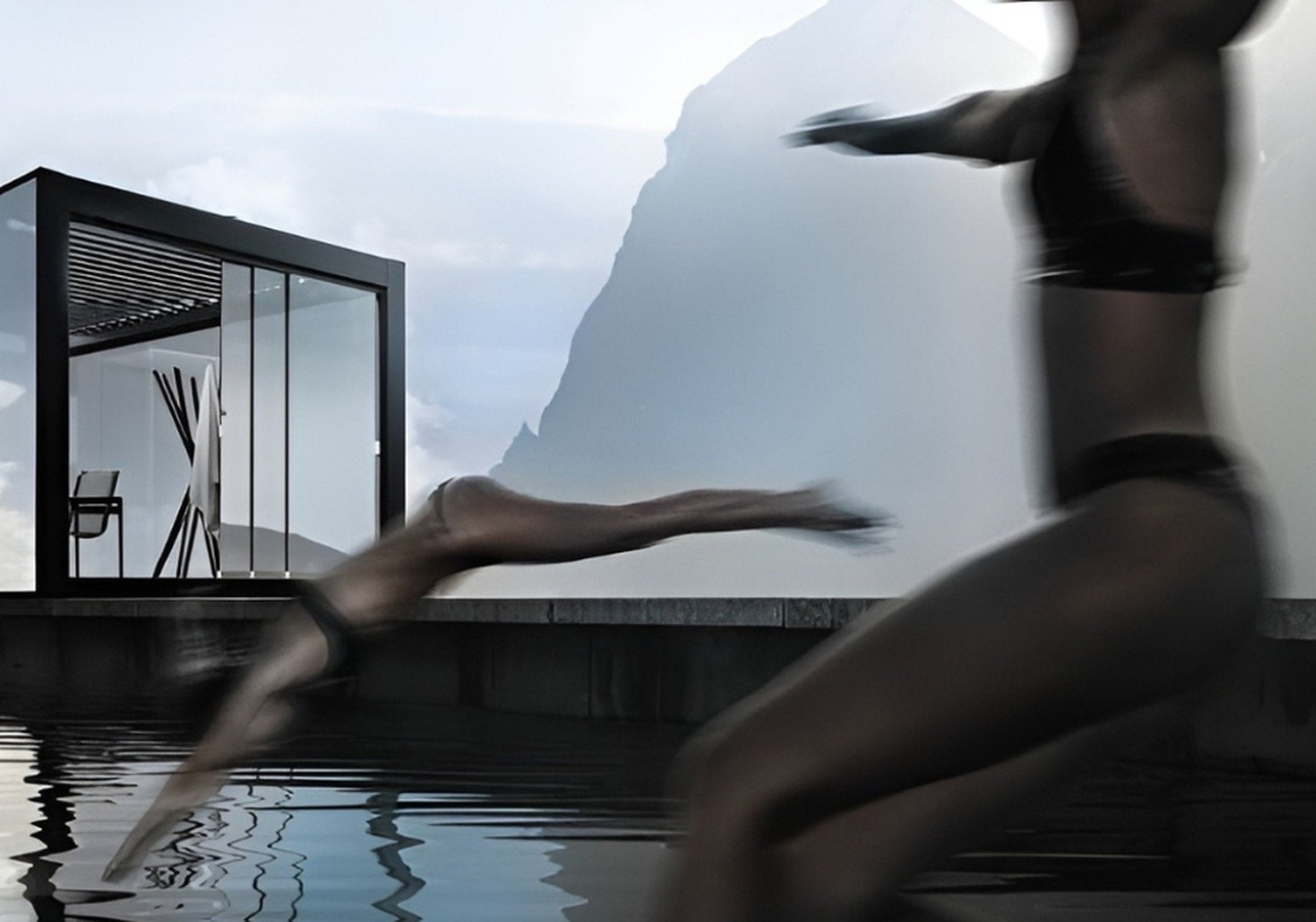 Vista su una pergola con copertura a lamelle in alluminio installata accanto a una piscina, con figura che si tuffa in primo piano e montagne sullo sfondo.