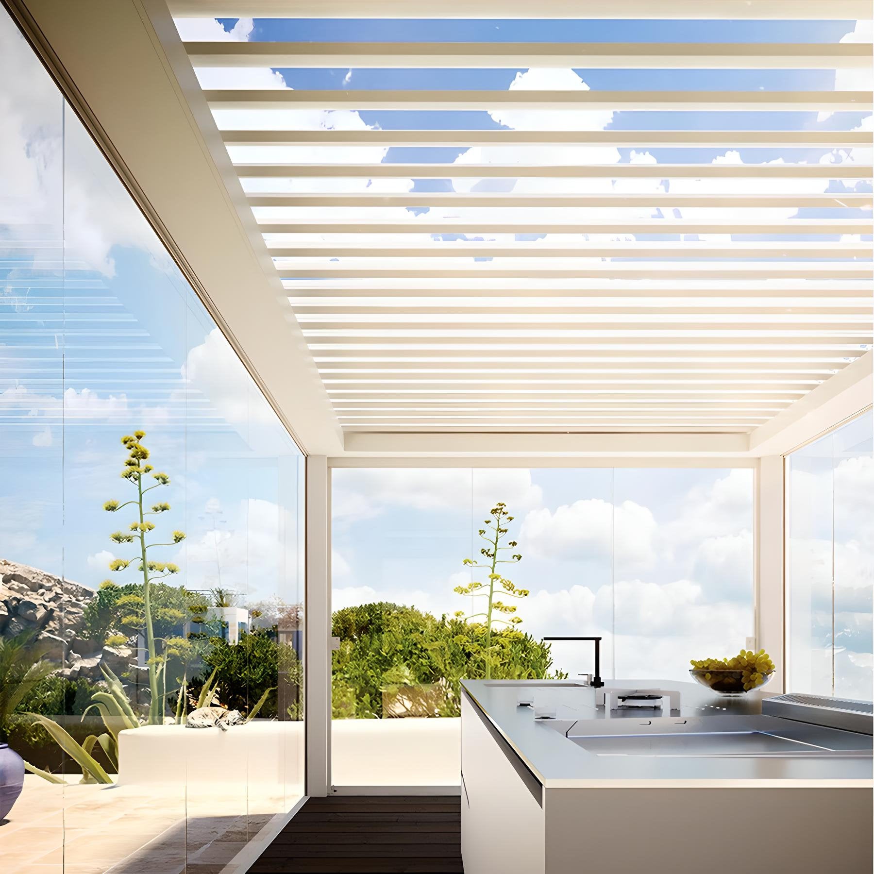 Spazio outdoor con cucina esterna, copertura a lamelle orientabili e pareti vetrate panoramiche, immerso nella vegetazione.