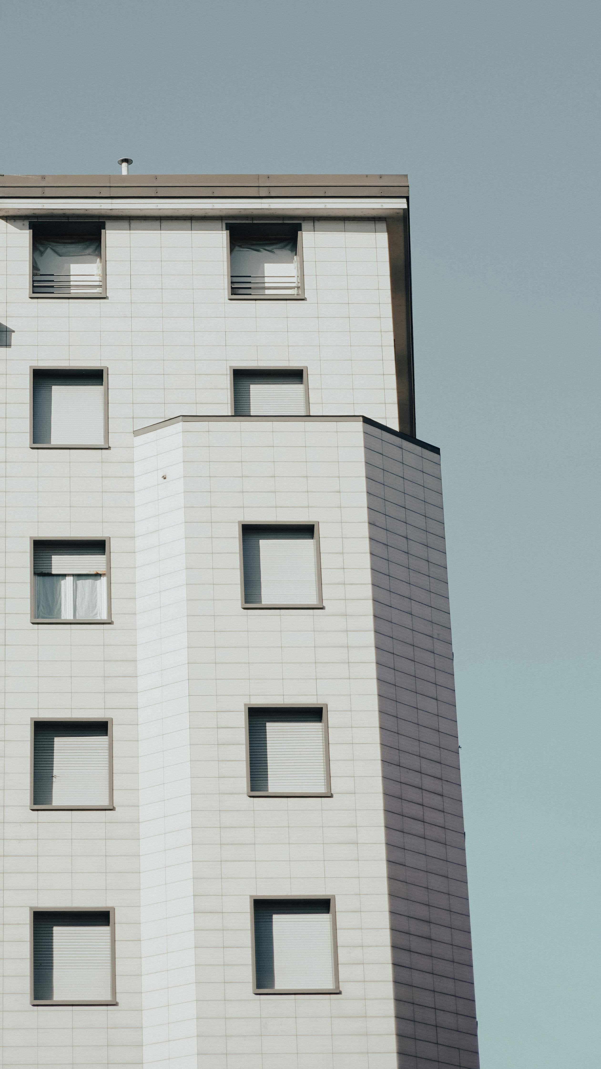 Vista architettonica di palazzo contemporaneo con tapparelle chiuse su tutte le finestre – Domotea Milano, soluzioni per il controllo della luce