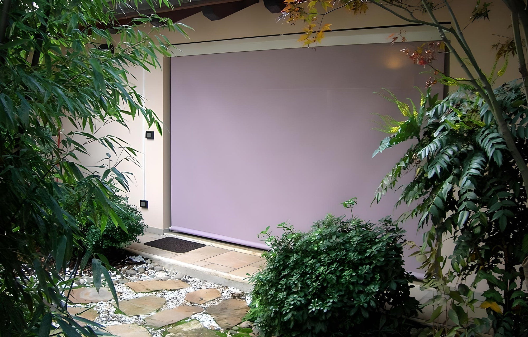 Tenda da sole a caduta verticale installata su veranda con giardino – Domotea Milano, schermature solari per esterni