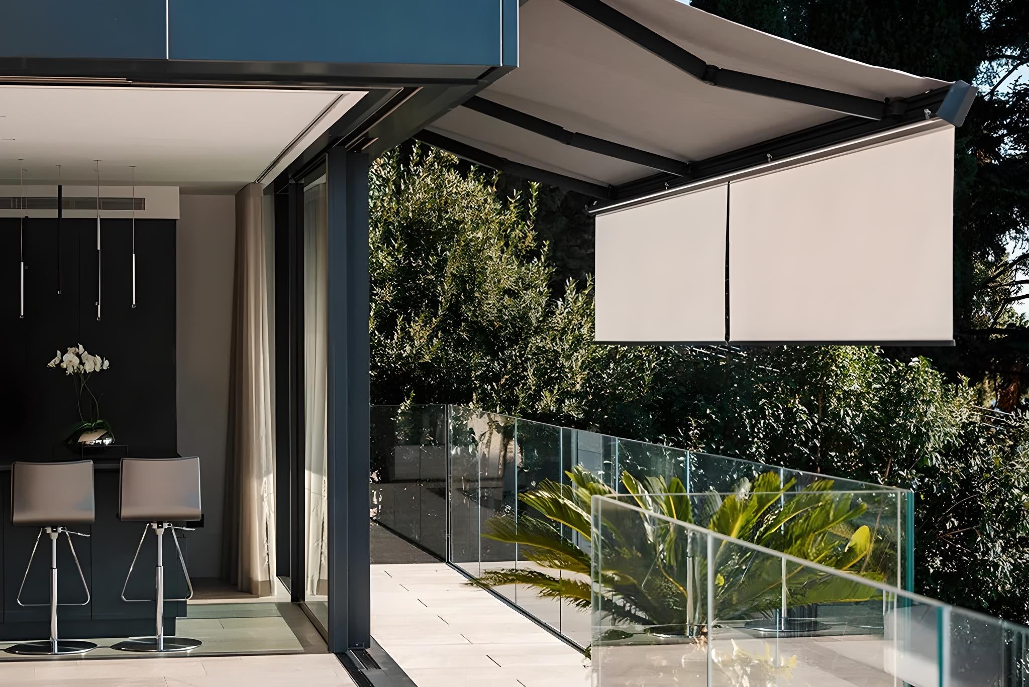 Tenda da sole a bracci installata su terrazzo moderno con pannelli verticali, 