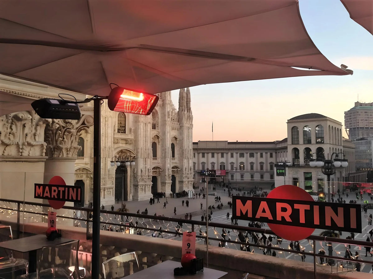 Lampada riscaldante Heliosa sotto una copertura sulla terrazza con vista sul Duomo di Milano.