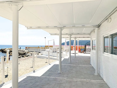 Vista dal basso del tessuto e delle traverse di Orizzonti Resstende su un pergolato esterno.